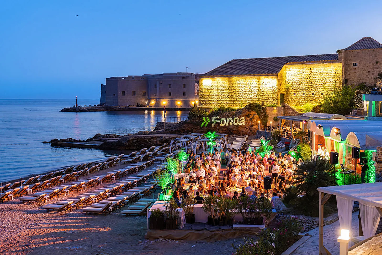 Dubrovnik's old town lit at blue hour above a Fonoa beachfront dinner