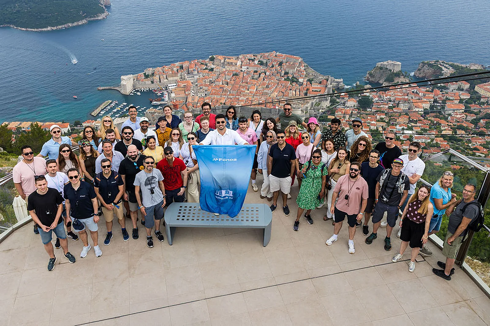 The full Fonoa team posed on Mount Srđ with Dubrovnik's old town and the Adriatic behind them